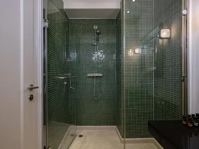 a bathroom with a shower with green tiles at Mediterranean villa Seaview privet pool in Tersanas