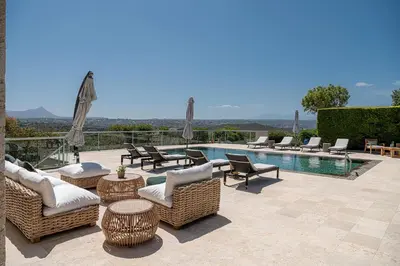a patio with wicker chairs and tables and a pool at Mediterranean villa Seaview privet pool in Tersanas