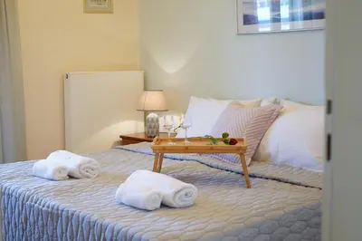 a hotel room with a bed with towels and a table at Kostoula's House Beachfront in Stalos