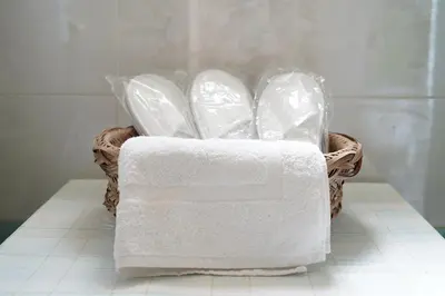 a basket of white towels sitting on a bathroom floor at Kostoula's House Beachfront in Stalos