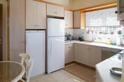 a kitchen with a white refrigerator and a table at Kostoula's House Beachfront in Stalos