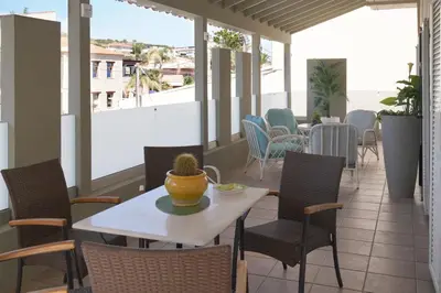 a patio with a table and chairs on a balcony at Kostoula's House Beachfront in Stalos
