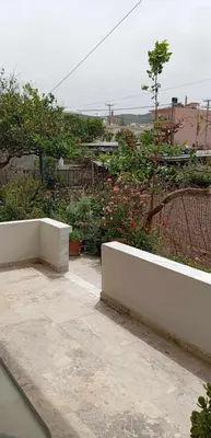 a garden with a white wall and some flowers at Maria's sala in Kissamos