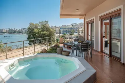 a hot tub on the balcony of a house at Elia Seaside Deluxe Apartment in Chania Town