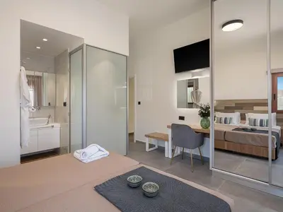 a living room with a bed and a bathroom at Elia Seaside Deluxe Apartment in Chania Town