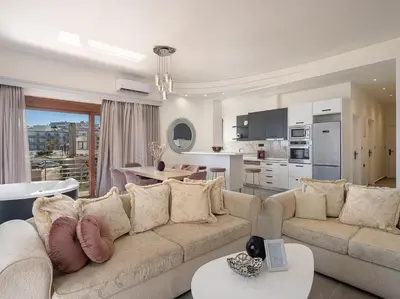 a living room with a couch and a kitchen at Elia Seaside Deluxe Apartment in Chania Town