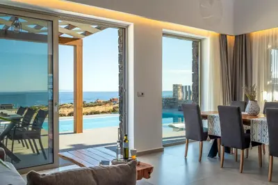 a dining room with a view of the ocean at FYSIOPHYLIA VILLAS in Frangokastello