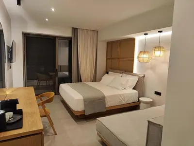 a hotel room with a bed and a living room at Ammos Paleochora Hotel in Palaiochóra
