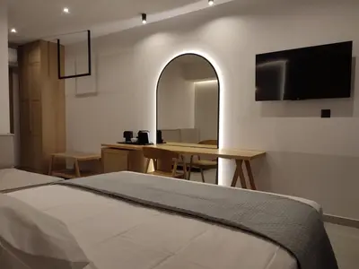 a bedroom with a bed and a desk and a television at Ammos Paleochora Hotel in Palaiochóra