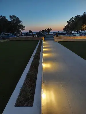 a long sidewalk with lights on it at night at Ammos Paleochora Hotel in Palaiochóra