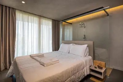 a bedroom with a large white bed with a window at Icarus Hotel in Kalamaki Chanion