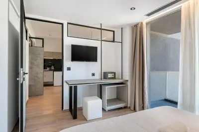 a bedroom with a desk and a tv in a room at Icarus Hotel in Kalamaki Chanion