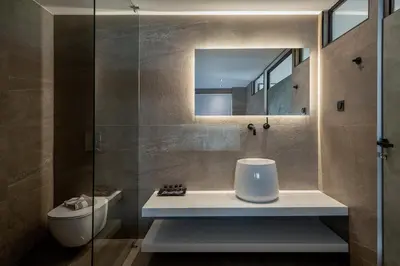 a bathroom with a sink and a toilet and a mirror at Icarus Hotel in Kalamaki Chanion