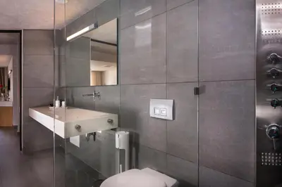 a bathroom with a sink and a toilet and a mirror at Icarus Hotel in Kalamaki Chanion