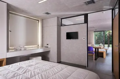 a bedroom with a bed and a tv on a wall at Icarus Hotel in Kalamaki Chanion
