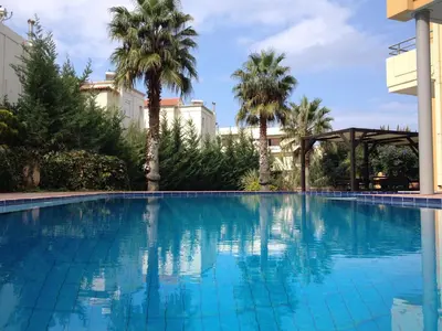 a swimming pool at a hotel with palm trees at Icarus Hotel in Kalamaki Chanion