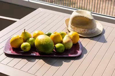 a plate of fruit on a table with a hat at Heliades Residence in Kounoupidhianá