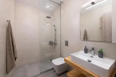 a bathroom with a white sink and a shower at Heliades Residence in Kounoupidhianá