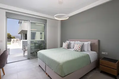 a bedroom with a bed and a balcony at Heliades Residence in Kounoupidhianá