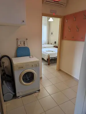 a room with a washing machine and a bedroom at ALMA central apartment in Chania Town