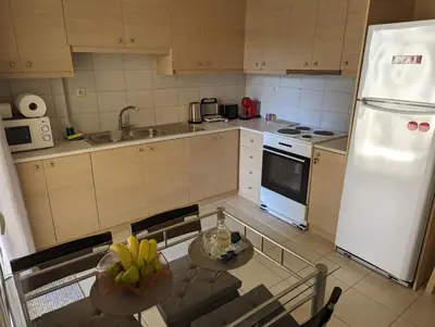 a kitchen with a table and a white refrigerator at ALMA central apartment in Chania Town