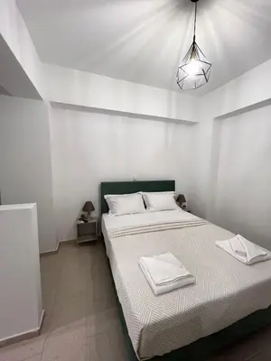 a white bedroom with a bed with towels on it at Domus Bettolo in Chania Town