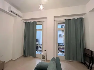 a living room with a couch and two windows at Domus Bettolo in Chania Town