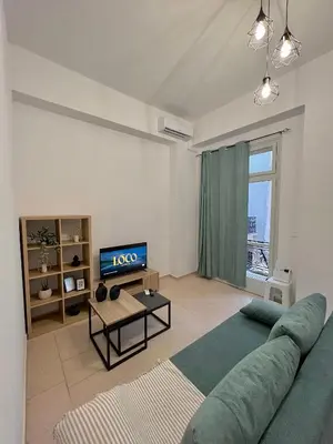 a living room with a green couch and a television at Domus Bettolo in Chania Town