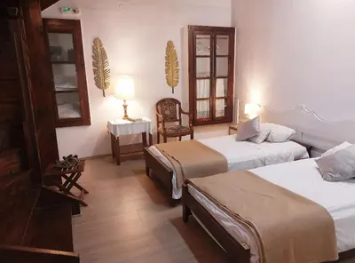 a room with two beds and a table and a chair at Myron House in Chania Town
