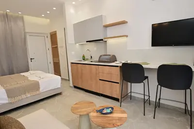 a room with a bed and a kitchen with a desk at Morpheas Rooms in Palaiochóra