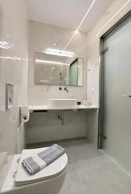 a white bathroom with a sink and a toilet at Morpheas Rooms in Palaiochóra