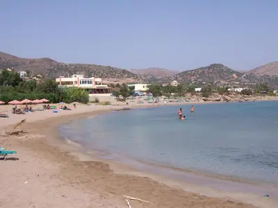 a beach with people swimming in the water at Morpheas Rooms in Palaiochóra