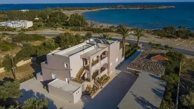 an aerial view of a house with the ocean at Morpheas Rooms in Palaiochóra