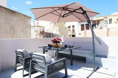a table and chairs with an umbrella on a balcony at Porto 57 in Chania Town