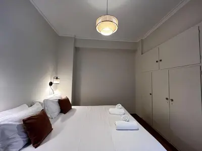a bedroom with a large white bed and a light at ZEN central flat with seaview by 8essentially in Chania Town