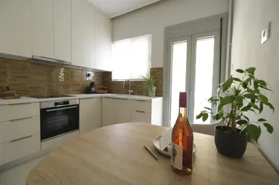 a bottle of wine sitting on a wooden table in a kitchen at ZEN central flat with seaview by 8essentially in Chania Town