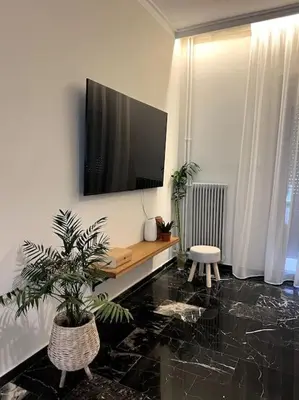 a living room with a flat screen tv on a wall at ZEN central flat with seaview by 8essentially in Chania Town