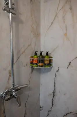 three bottles of beer sitting on a shelf in a bathroom at Perion stone apartment sea front in Kolymvari
