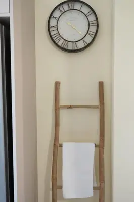 a clock on a wall next to a wooden shelf at Perion stone apartment sea front in Kolymvari