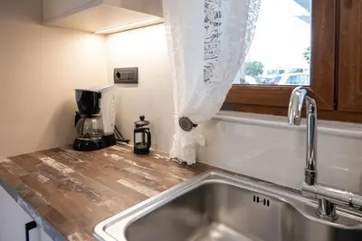 a kitchen counter with a sink and a window at Perion stone apartment sea front in Kolymvari