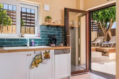 a kitchen with a sink and a sliding glass door at Anna Boutique Apartment in Kato Daratso