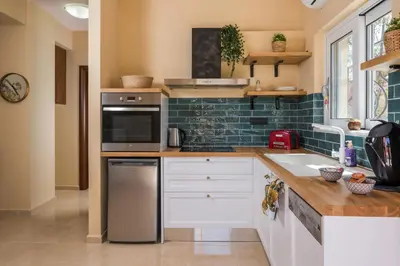 a kitchen with white cabinets and a stove top oven at Anna Boutique Apartment in Kato Daratso