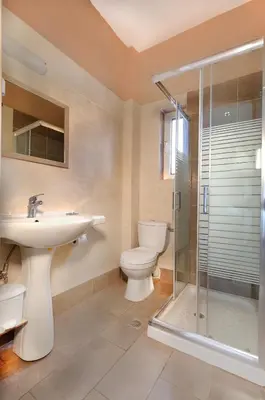 a bathroom with a toilet and a sink and a shower at El Greco Studios in Agia Marina Nea Kydonias