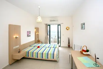 a bedroom with a bed and a table at Aptera Paradise With Sea View in Megála Khoráfia