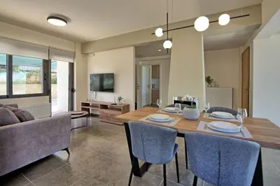 a dining room with a table and a couch at Iris by PosarelliVillas in Kounoupidhianá