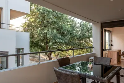 a view from the balcony of a house with a table and chairs at Iris by PosarelliVillas in Kounoupidhianá