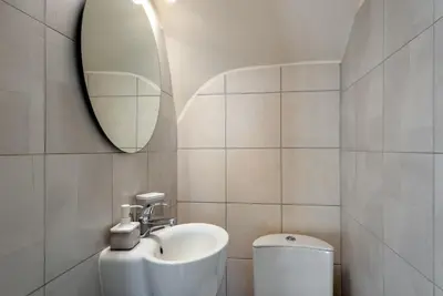 a bathroom with a sink and a mirror and a toilet at Iris by PosarelliVillas in Kounoupidhianá