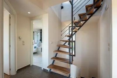 a spiral staircase in a house with a hallway at Iris by PosarelliVillas in Kounoupidhianá