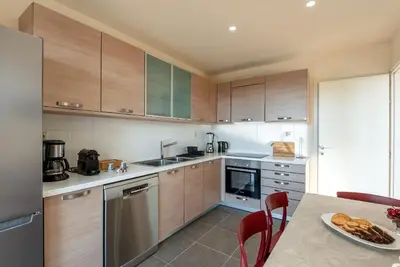 a kitchen with wooden cabinets and a table with a plate of food at Dioni by PosarelliVillas in Kounoupidhianá