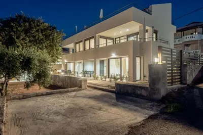a large white house at night with a driveway at Aelia by PosarelliVillas in Kounoupidhianá